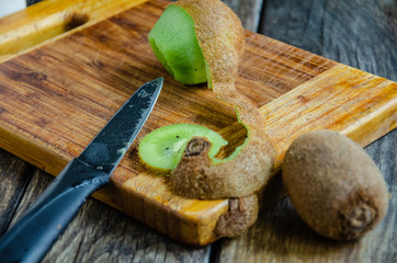Kiwi on a cutting board, sliced in the kitchen.