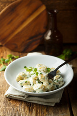Homemade potato gnocchi with creamy basil sauce