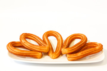 Naklejka premium served spanish fritters on white background