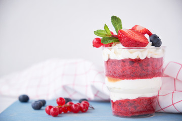 Cake dessert. Trifle red velvet in glass with fresh berries, mint leaves.