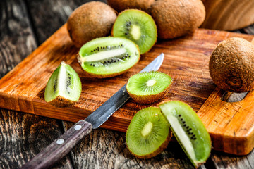 Kiwi on a cutting board, sliced in the kitchen.