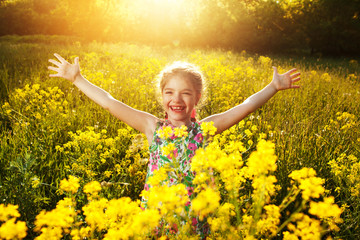 Naklejka na ściany i meble Happy little girl among yellow wildflowers