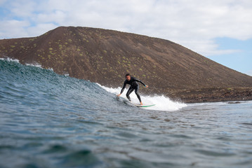 surfer riding waves on the island of fuerteventura in the Atlantic Ocean