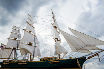Scale model of a wooden sailing ship on the coast of the Baltic Sea on a cloudy spring day