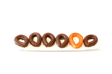 small chocolate spanish fritters in a white dish on white background