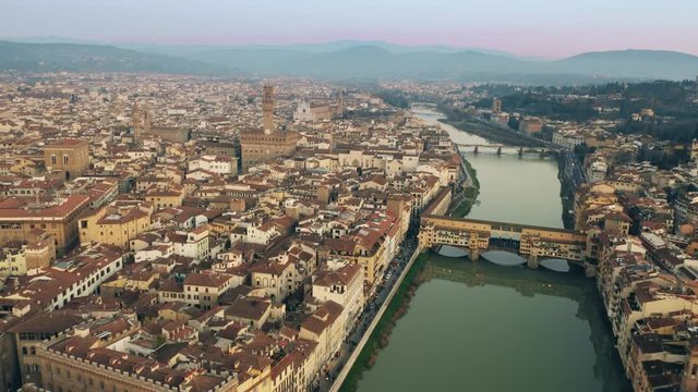 Crowded Ponte Vecchio bridge in the evening, aerial view. Florence, Italy