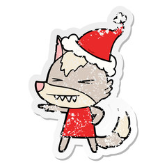 angry wolf distressed sticker cartoon of a wearing santa hat