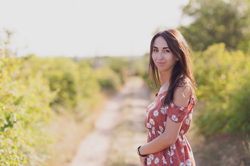 Fototapeta premium Summer lifestyle portrait of beautiful romantic girl holding bouquet of wild flowers.