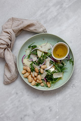 Vegan salad with beans arugula onions apple and vegan parmesan cheese