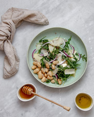 Vegan salad with beans arugula onions apple and vegan parmesan cheese