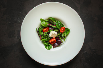 Healthy salad, leaves salad mix in a white plate and cheese (green, juicy snack). food background - Image