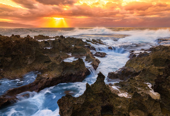 Ocean crashing over rocks in Oahu