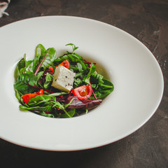 Healthy salad, leaves salad mix in a white plate and cheese (green, juicy snack). food background - Image