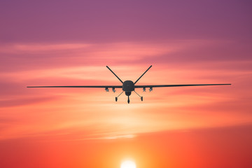 Fototapeta na wymiar Unmanned military drone patrols the territory at sunset, view is straight ahead.