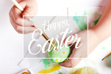 Kid hand painted boiled Easter eggs, paints and brushes on a white table. Preparation for the...