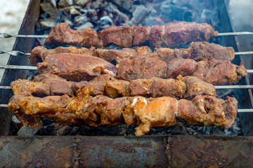 Skewers with meat kebabs on the grill with smoke