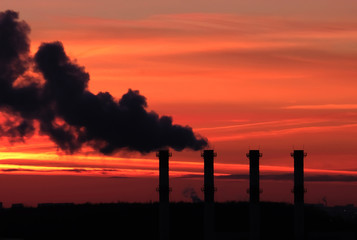 concept. environmental pollution. smoke from the pipes against the backdrop of a beautiful sunset