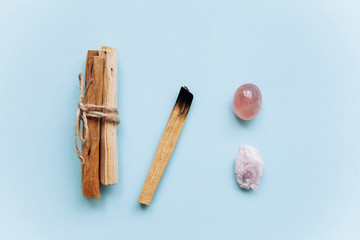 A set of wooden sticks Palo Santo on a blue background. Nearby are special stones - minerals. They are used in religious ceremonies.
