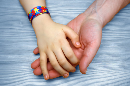 Autism Awareness Picture. Father holding hand her Autistic Child