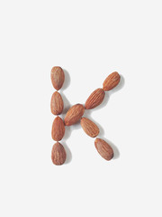 Isolated alphabet letter K made by almonds