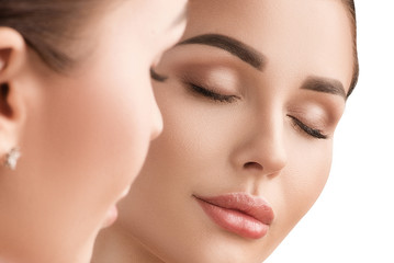 Fototapeta premium Beautiful girl looks in the mirror. Cosmetology, clean skin