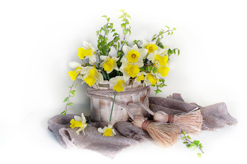 Spring flowers.Still life yellow daffodils in a wicker basket isolated on a light background