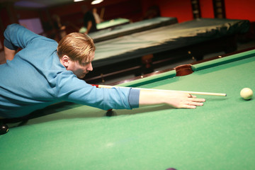 Serious man playing billiards