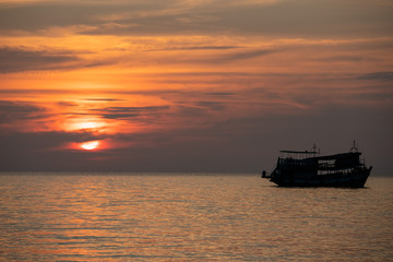 Naklejka na ściany i meble Fischerboot im Sonnenuntergang im Ozean