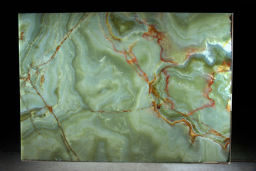Green onyx with red veins on a dark background, natural stone