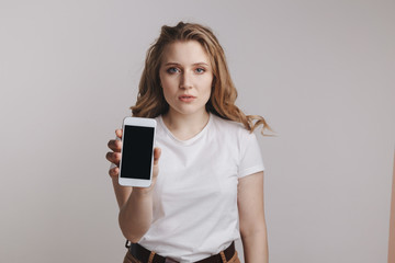 Girl holding white iphone isolated over the white background