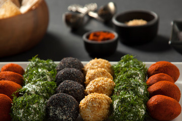 Cheese platter, appetizer. Spicy, sesame, blue poppy, red pepper, parsley cheese balls. With whole wheat chips