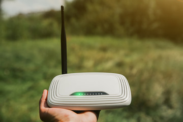 Man is looking for wi-fi signal in the nature. Guy is lost and holding router in his hands...