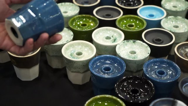 People choosing hookah. Smoking tobacco at exhibition. Shisha bowl at event