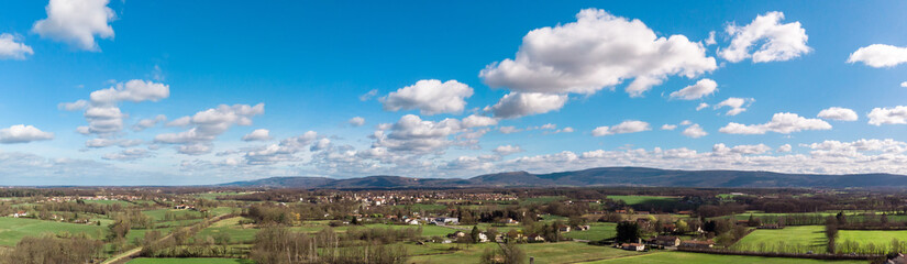 Fototapeta na wymiar vue panoramique et aérienne sur la campagne avec des montagnes en fond