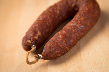 Luftgetrockneter Mettwurst Ring aus Schweinefleisch auf Holz Brett 