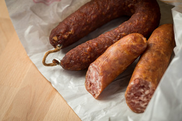 Ringwurst Salami und Bierbeißer Wurst in Wachspapier auf Vesper Holzbrett