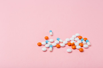 Obraz premium Different pharmaceutical medicine pills, tablets and capsules on light pink background. Copy space. Medicine medical concept. Be healthy. Selective focus.