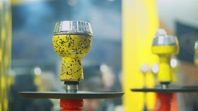 People choosing hookah. Smoking tobacco at exhibition. Shisha bowl at event