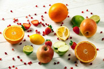 Fresh mixed fruits.Healthy eating, dieting.Love fruits, clean eating. Season fruits. Pomegranate seeds, apple, orange, lemon, strawberry on wood patterned background. 