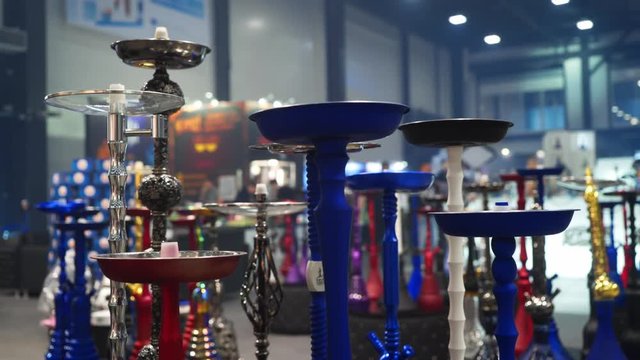 People choosing hookah. Smoking tobacco at exhibition. Shisha bowl at event