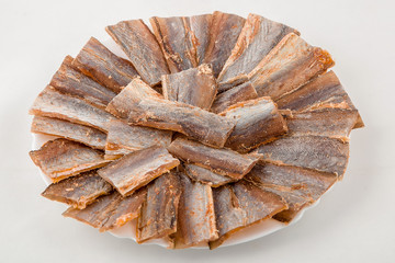 Chips of fish pieces on a plate on a white background