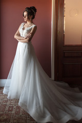 Fototapeta premium Portrait of a beautiful bride woman in elegant white wedding dress. Luxurious apartments. 
