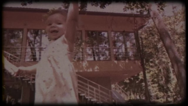 Family video archive. Retro camera 8 mm. Old film. Young father playing with his little daughter and son near the house. Family games. Holiday, holidays. Family together