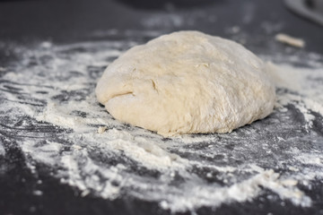 Fototapeta na wymiar dough on a black table, homemade food