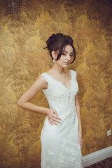 Portrait of a beautiful bride woman in elegant white wedding dress. Luxurious apartments. 