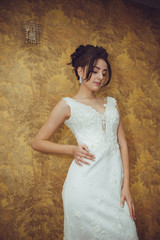 Portrait of a beautiful bride woman in elegant white wedding dress. Luxurious apartments. 