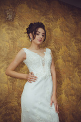 Portrait of a beautiful bride woman in elegant white wedding dress. Luxurious apartments. 