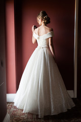 Fototapeta premium Portrait of a beautiful bride woman in elegant white wedding dress. Luxurious apartments. 