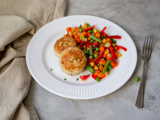 Chicken cutlets with steamed Mix vegetables, Chicken meat balls on white plate. Heathy lunch, diet food. Selective focus, close up.