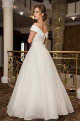 Naklejka premium Portrait of a beautiful bride woman in elegant white wedding dress. Luxurious apartments. 